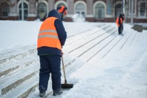 Workers sweep snow from road in winter, Cleaning road from snow storm